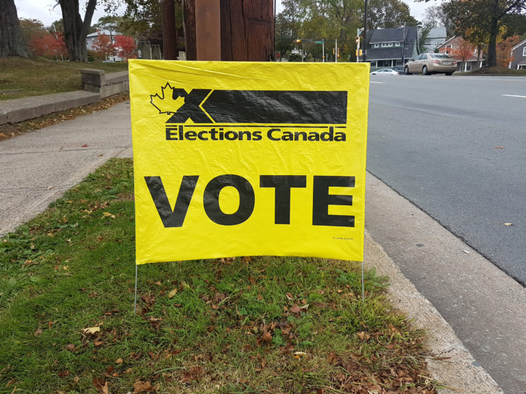 une panneau jaune d'Elections Canada qui dit «VOTE»