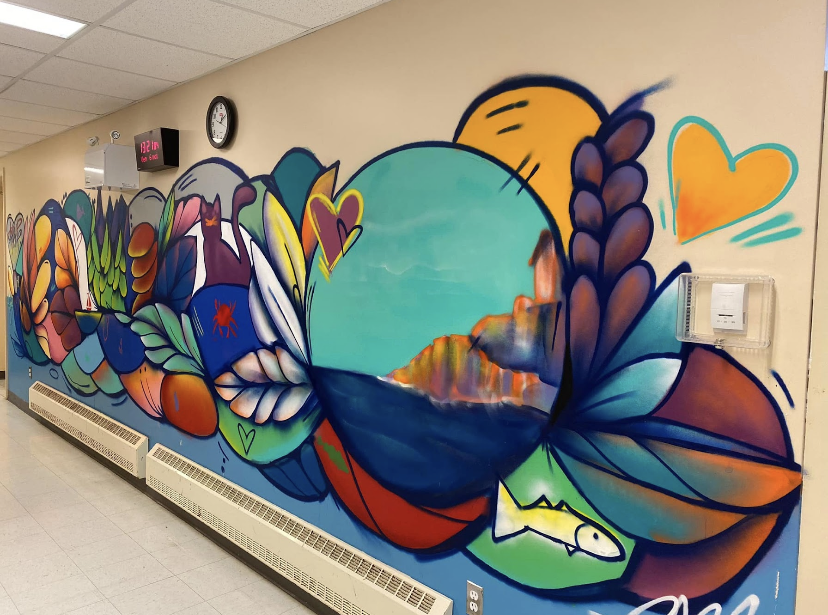 Une murale multicolore sur un mur à l'intérieur d’une école.