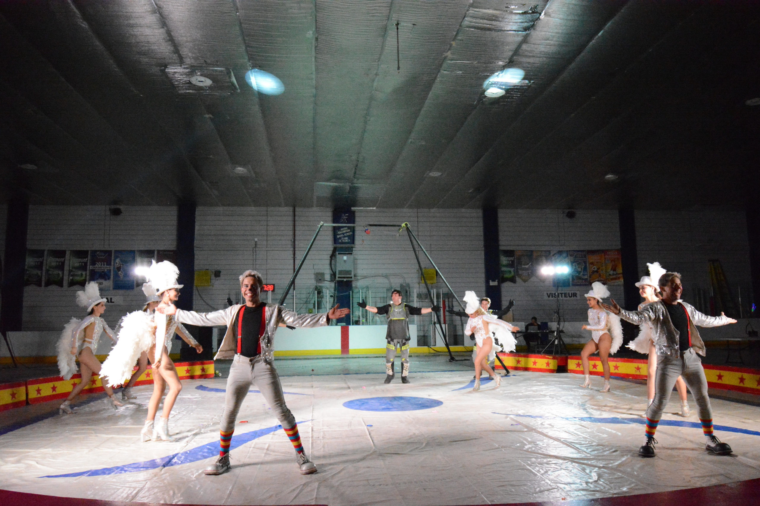 Des acrobates de cirque font un spectacle dans une aréna blanche. 