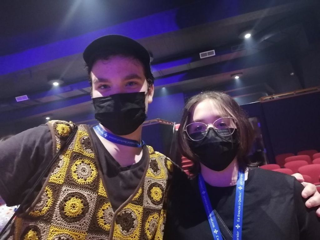 Deux personnes qui portent des masques médicaux noirs sont côte-à-côte. 